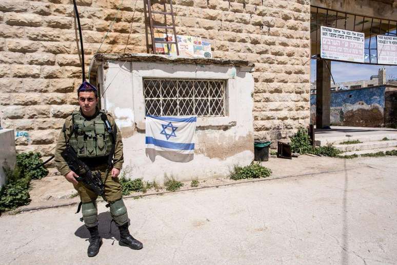 Soldado israelense guarda a entrada de um assentamento judeu em Hebron, na Cisjordânia