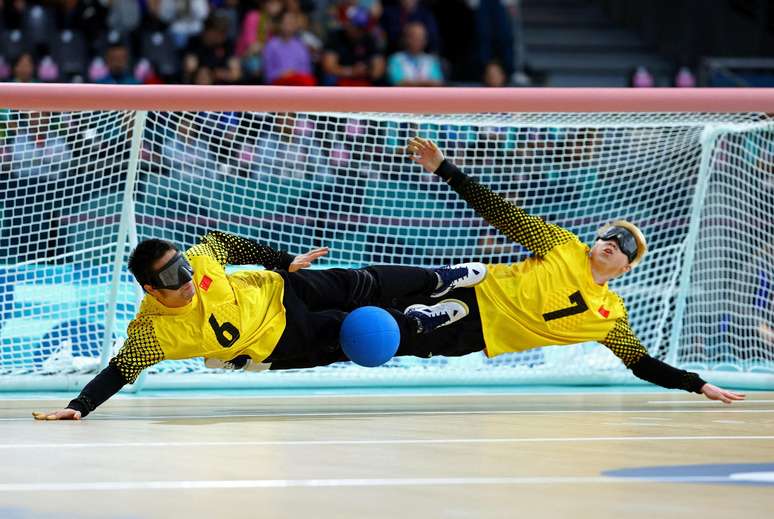 Yu Qinquan e Yu Deyi da China no meio de uma partida de goalball. Este é um esporte praticado exclusivamente por atletas com deficiência