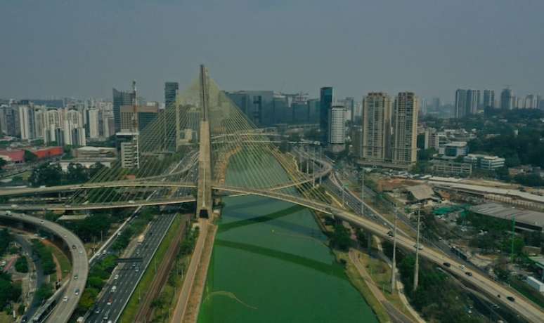 Rio Pinheiros apresenta coloração verde devido à estiagem em São Paulo.