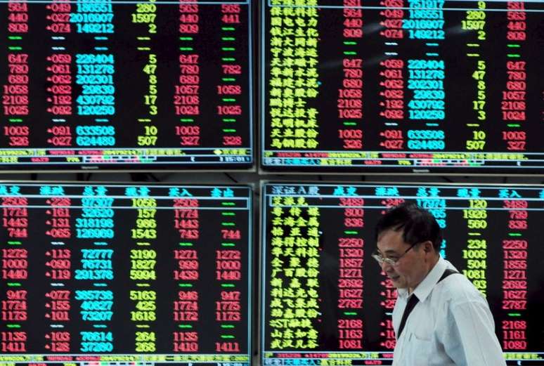 Investidor passa em frente a painel eletrônico com informações do mercado financeiro em corretora de Jiujiang, na província chinesa de Jiangxi
16/09/2015 REUTERS/China Daily