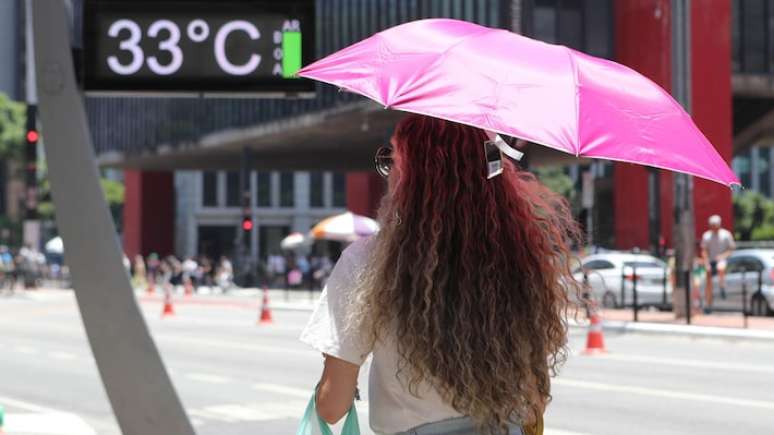 Movimentação na Avenida Paulista com termômetros marcando 33 graus.