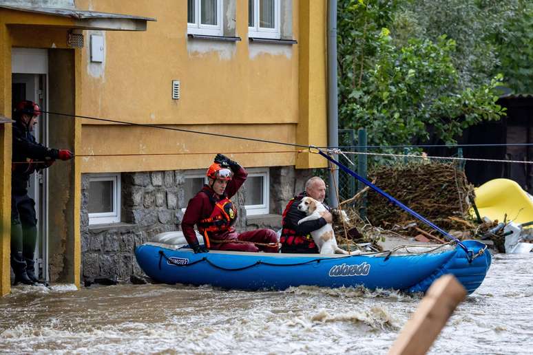 Los bomberos rescatan a un residente y a un perro de una casa tras una inundación en la ciudad de Jesenik, República Checa