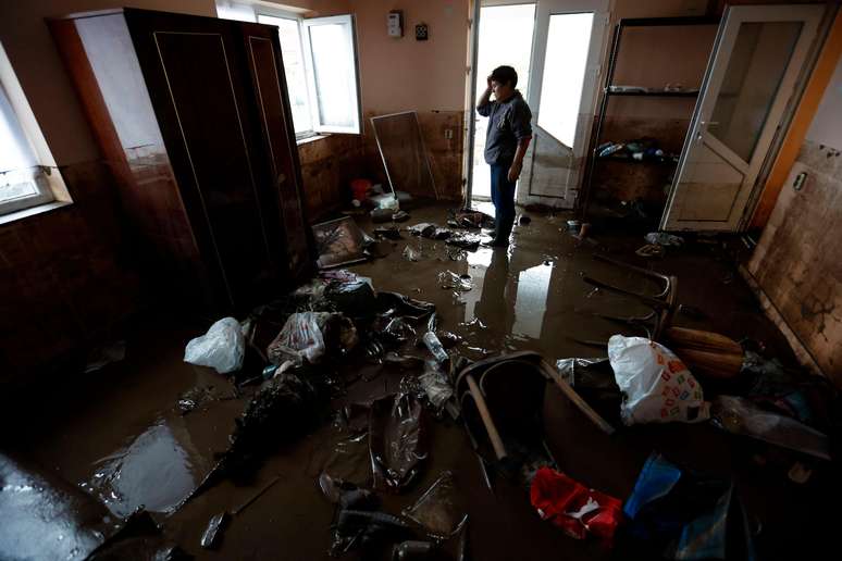 A resident sees what remains of her house after flooding in the village of Peccia near the city of Galati in Romania.