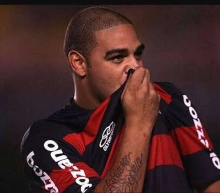 Adriano Imperador beijando a o escudo na camisa do Flamengo.