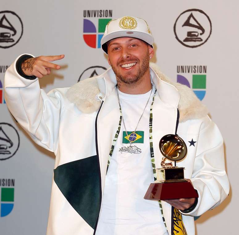 Rapper Cabal segurando o Grammy Latino de Vida Marvada. Artista representou a parceria com Chitãozinho e Xororó na premiação.