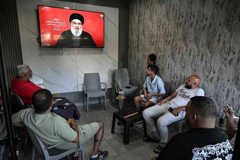 Refugiados palestinos ouvem um discurso do líder do Hezbollah, Hassan Nasrallah, em um café na entrada do campo de Sabra, em Beirute. Joseph Eid/AFP via Getty Images