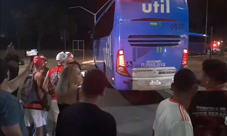 Fans melempar popcorn ke bus tim merah dan hitam yang tiba di Rio -