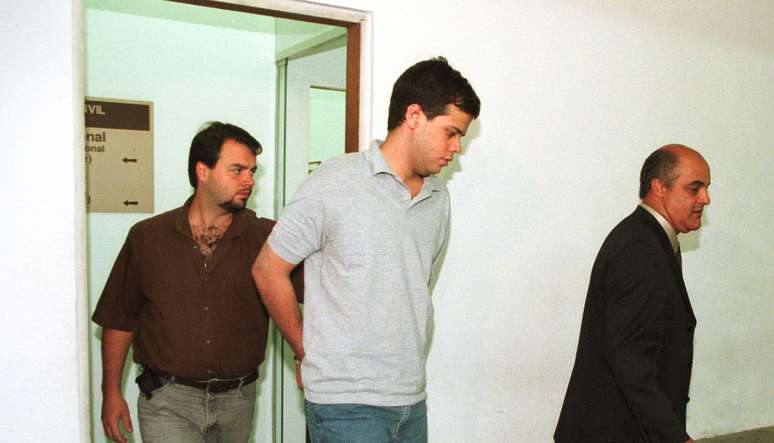 Mateus da Costa Meira (c), que matou 3 pessoas e deixou outras 4 feridas após disparar tiros de metralhadora em uma sala de cinema do Shopping Morumbi, é apresentado no 96º DP em 1999