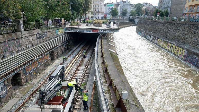 Trabalhadores limpam os detritos dos trilhos de metrô, depois do transbordamento do canal Wienfluss em Viena, causado pela tempestade Boris.