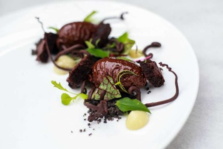 Floresta de chocolate, sobremesa de Rodrigo Ribeiro do Petí, que leva chocolate em diversas versões e texturas com pancs e gel de cambuci