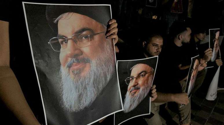 Apoiadores do líder do Hezbollah, Hassan Nasrallah, carregam suas fotografias enquanto se reúnem em Sidon, no Líbano, após sua morte.