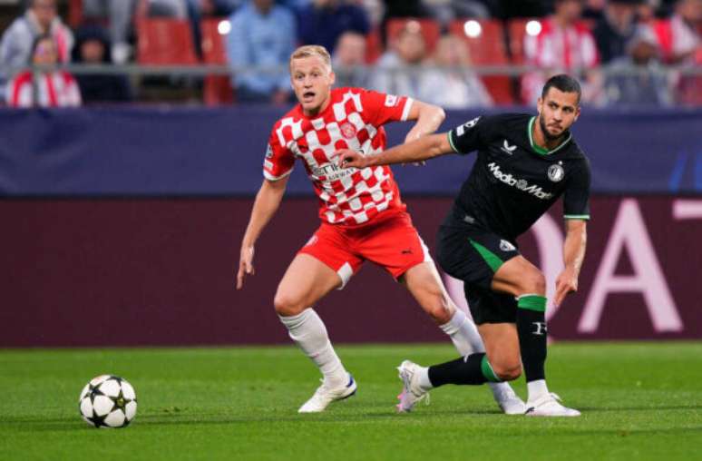 Pedro Salado/Getty Images - Legenda: Donny van de Beek (a esquerda)  tenta ganhar para o Girona a disputa de bola com Hancko, do Feyenoord