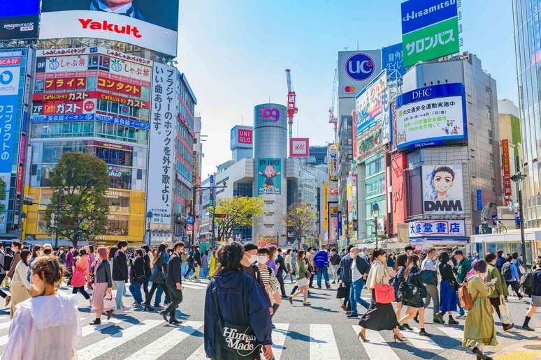 Muitas pessoas atravessando as ruas no Cruzamento Shibuya, em Tóquio