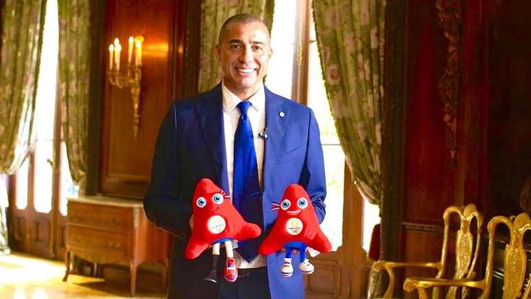 Ex-jogador segura mascote da Olimpíada de Paris 2024 –