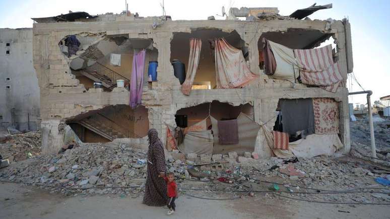 As consequências da ofensiva israelense em Gaza e no Líbano foram devastadoras. Na foto, uma mulher e uma criança caminham pela cidade de Khan Younis