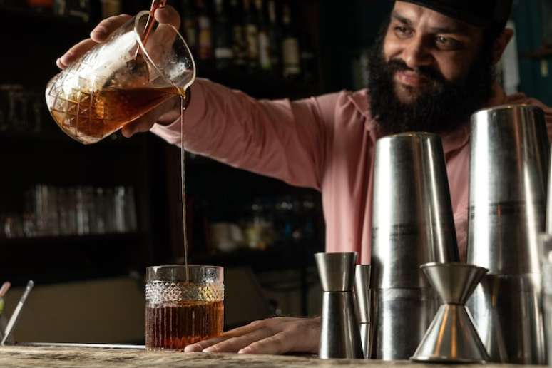 Chris Carijó prepara a sua versão de rabo de galo: a base é uma infusão de café com cachaça e casca de laranja-baía