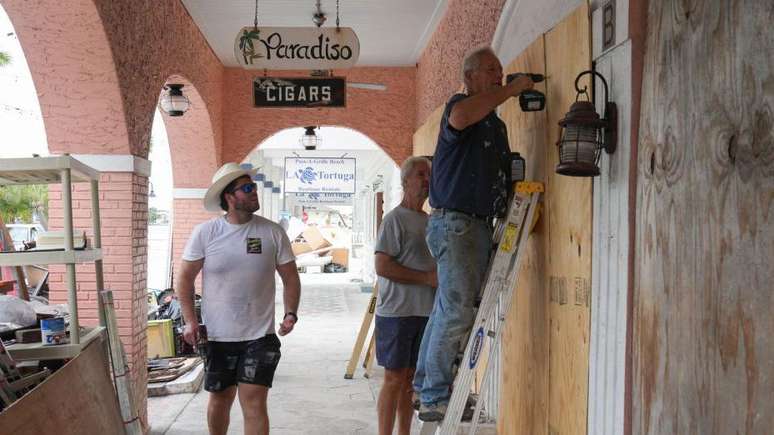 Moradores colocam tábuas para impedir que ventos danifiquem janelas