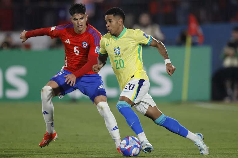 Thomas Galdames, do Chile, disputa o lance com Savinho, do Brasil, durante partida válida pela 9ª rodada das Eliminatórias Sul-Americanas para a Copa do Mundo FIFA 2026, no Estádio Nacional de Chile, em Santiago, nesta quinta-feira, 10.