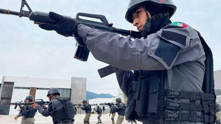 Policiais com armas apontadas em Tampico.