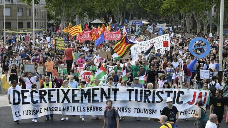 Manifestantes seguram faixa com dizeres 'Diminuição do turismo já' em protesto em julho