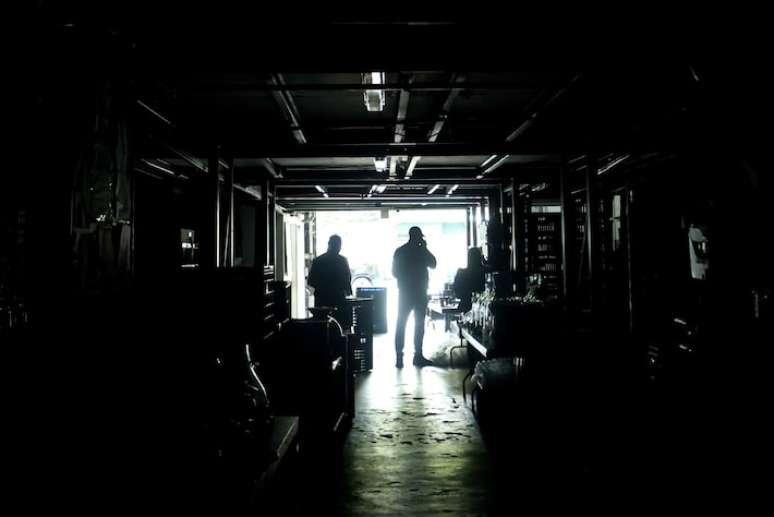 Comerciantes da Rua Joaquim Antunes no bairro de Pinheiros, zona oeste de São Paulo, trabalham a luz de vela.