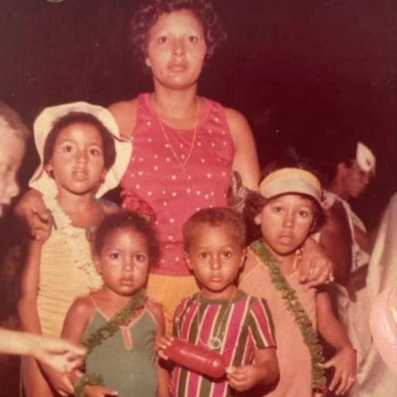 A mãe Maria Auxiliadora Santos e os filhos. Márcio segura a garrafa e veste uniforme do Fluminense, mas é torcedor do Flamengo.