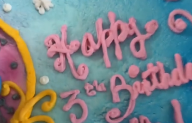 Madre muestra el pastel de cumpleaños de su hija