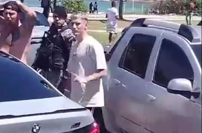 Varela sendo parado pela Polícia durante a confusão na praia –