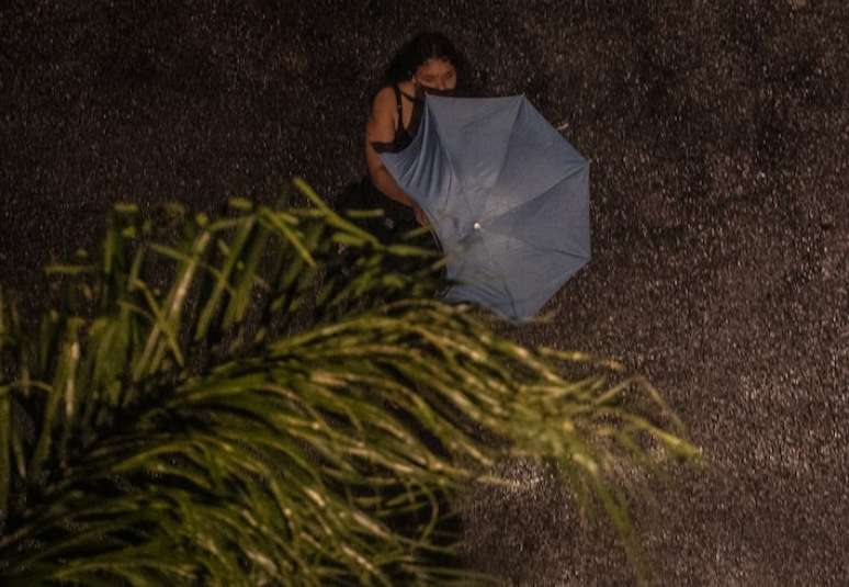 Pedestre enfrenta chuva e uma forte ventania na zona norte da capital paulista na noite de quinta-feira, 24.