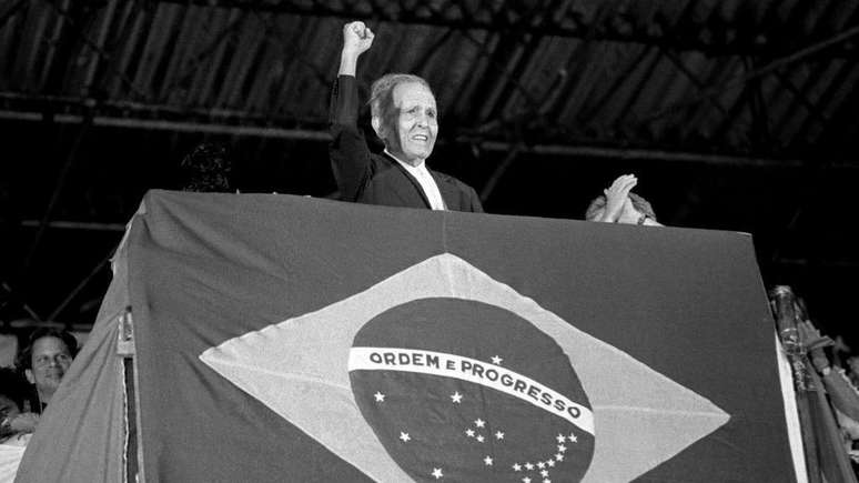 O ex-secretário-geral do Partido Comunista Brasileiro, Luis Carlos Prestes, levanta o punho enquanto faz campanha em um comício de Lula durante o segundo turno das eleições de 1989