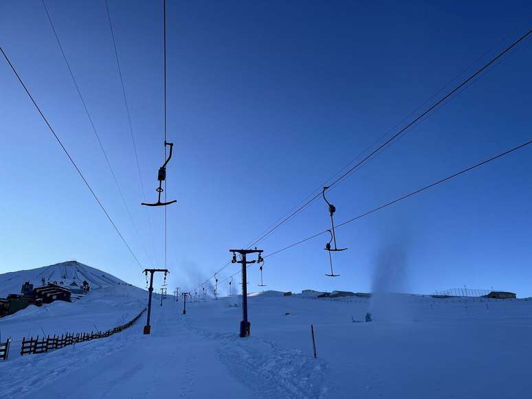 Teleférico e neve artificial jorrada por máquinas