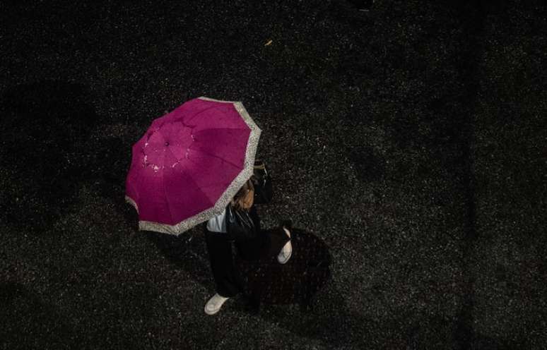 Pedestre enfrenta chuva e uma forte ventania na zona norte da capital paulista na noite do último dia 24.