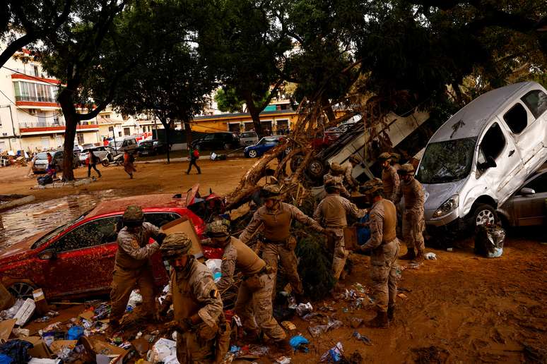 Membros do Exército Espanhol trabalham na limpeza de rua coberta de lama e destroços após enchentes em Massanassa, próximo a Valência, Espanha. (3/11/2014)