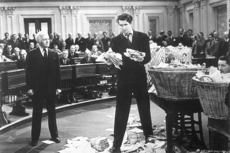 1939: American actor James Stewart (1908 - 1997) (R) clutches a wad of letters as British actor Claude Rains looks on, while standing on the floor of the U.S. Senate in a still from director Frank Caprafs film, 'Mr. Smith Goes to Washington'. (Photo by Hulton Archive/Getty Images)