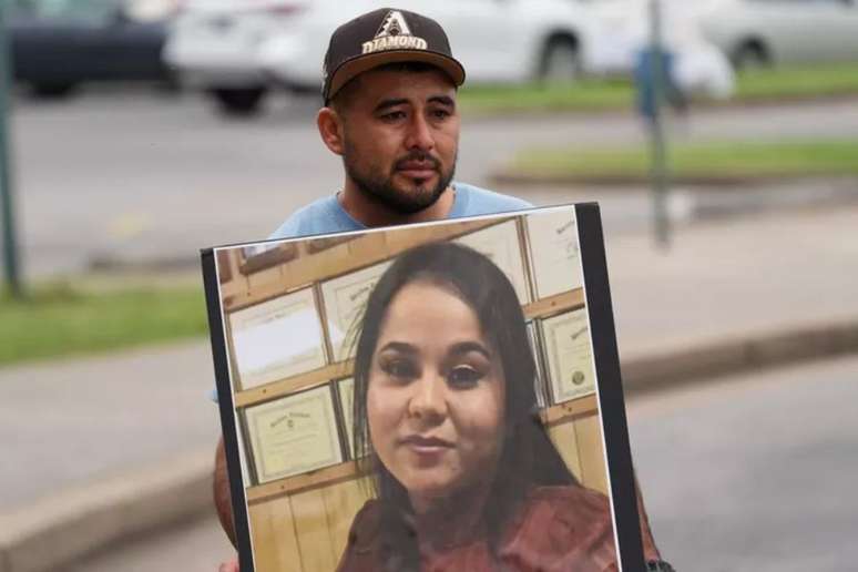 Marido de Rosa Andrade segura foto da esposa, morta em enchente causada pelo Furacão Helene