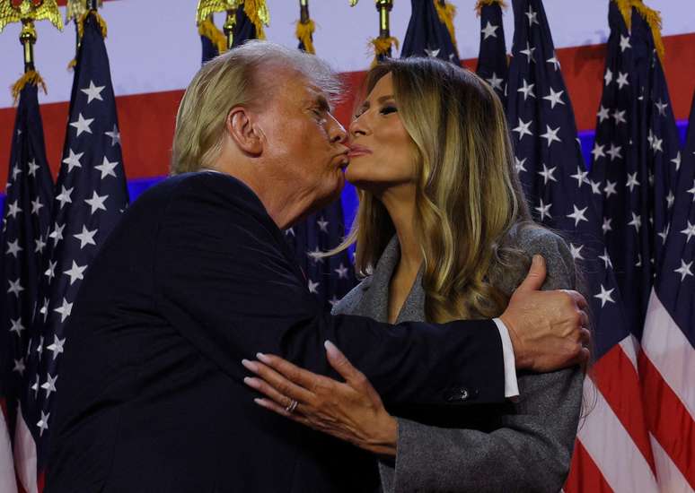 O candidato presidencial republicano e ex-presidente dos EUA, Donald Trump, beija sua esposa Melania em seu comício, no Palm Beach County Convention Center em West Palm Beach, Flórida, EUA, 6 de novembro de 2024. 
