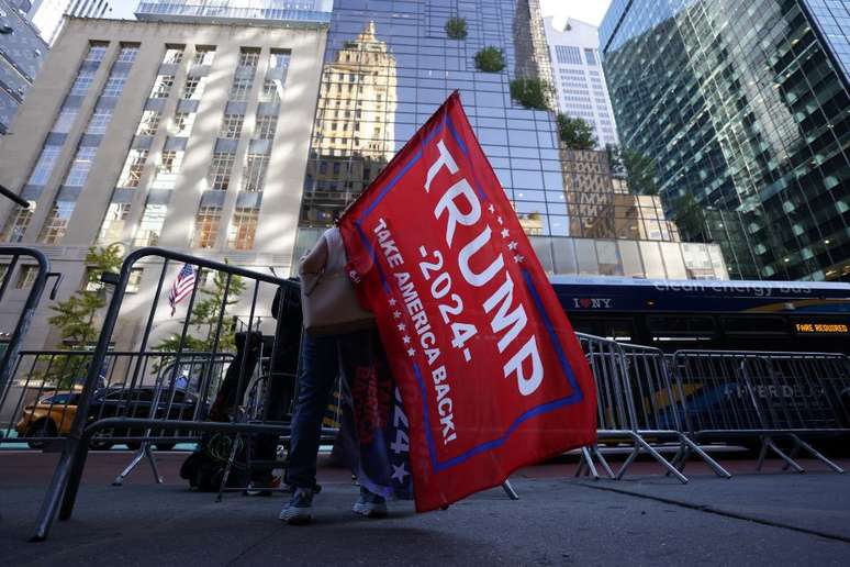 Uma pessoa segura uma bandeira em apoio a Donald Trump do lado de fora da Trump Tower, após a eleição de Donald Trump para presidente dos Estados Unidos, em Nova York. (6/11/2024)