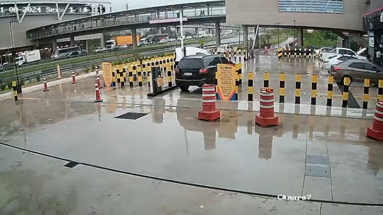 Carro preto, que estava com dois seguranças, retorna ao estacionamento próximo ao Aeroporto de Guarulhos para verificar o que aconteceu com o carro branco, que estava com o capô levantado