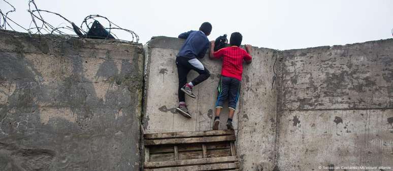 Crianças observam por cima do "muro da vergonha" em Lima, Peru