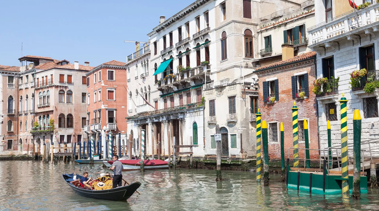 Sandolo com turistas navega em canal de Veneza