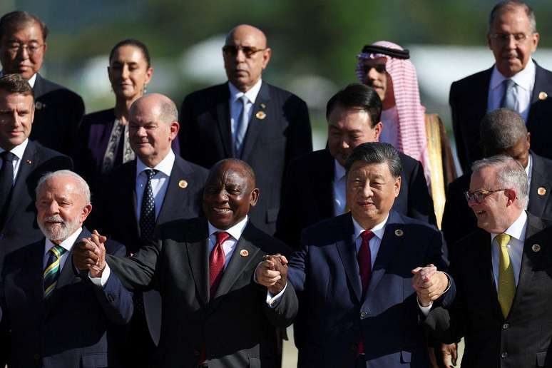 Líderes de países, entre eles Lula, posando para foto, alguns deles de mãos dadas e erguidas e sorrindo 