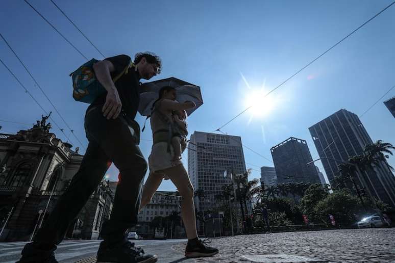 Pedestres caminham pelo Vale do Anhangabaú em dia de calor na capital paulista.