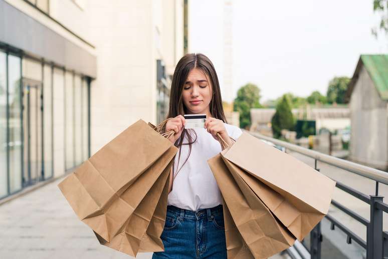 Mulher fazendo muitas compras com o cartão de crédito.