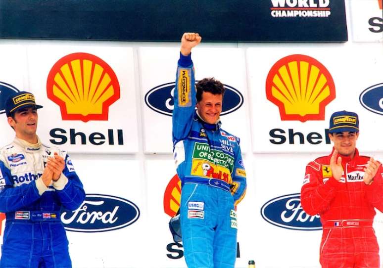 Michael Schumacher ao centro da foto no GP do Brasil de 1994, quando venceu a prova pela Benetton. O pódio também contou com Damon Hill, da Williams, e Jean Alesi, da Ferrari.