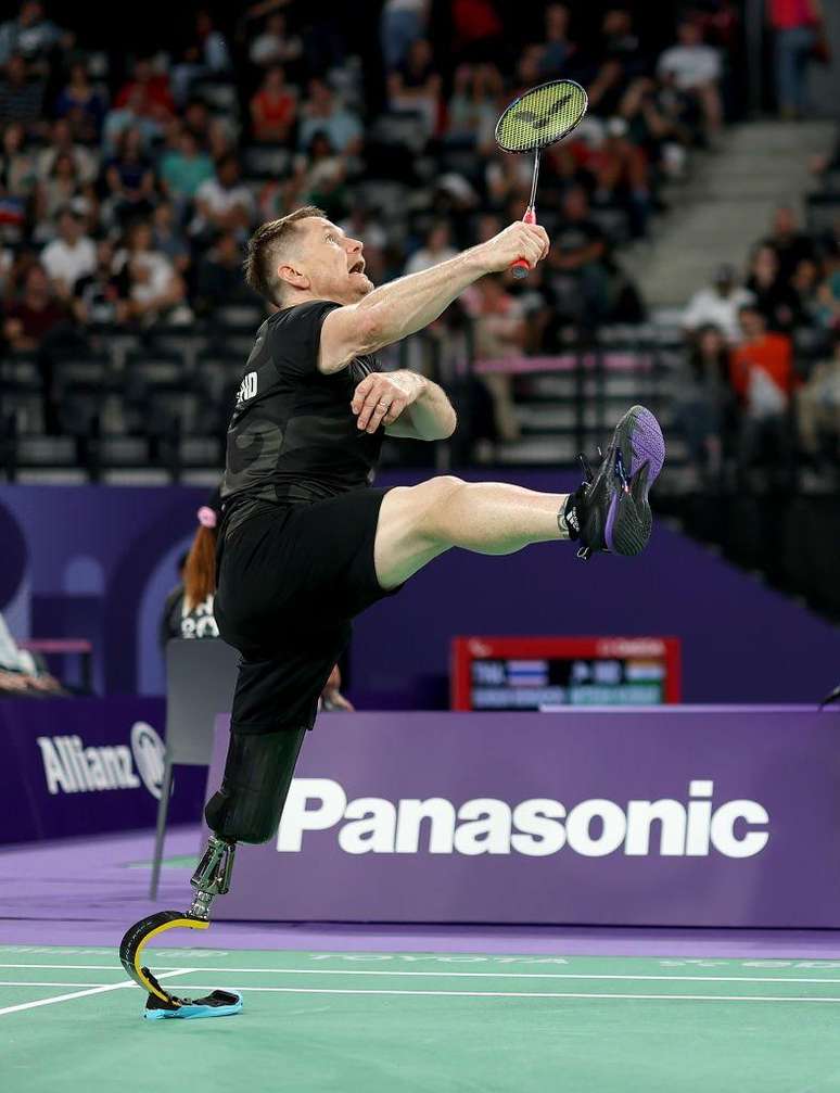 Wojtek Czyz da Nova Zelândia em uma partida de badminton