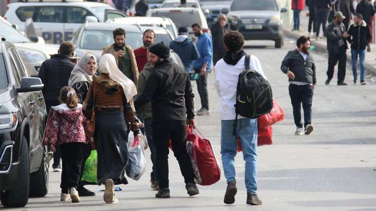 Refugiados sírios caminham em direção ao posto de fronteira de Masnaa, entre o Líbano e a Síria, para voltar para casa em 8 de dezembro, após a queda do regime de Bashar al-Assad