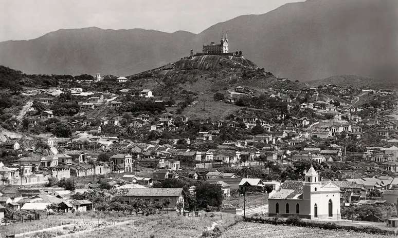 No alto, Igreja da Penha. Morro abrigava quilombo no século 19. Décadas depois, surgem favelas como a Vila Cruzeiro.