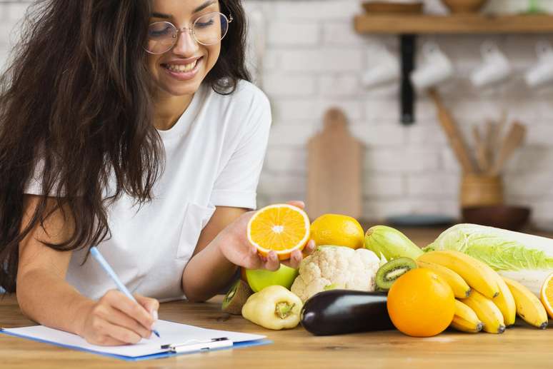 Mulher anotando os nutrientes necessários paraunibet prix d ameriquedieta.