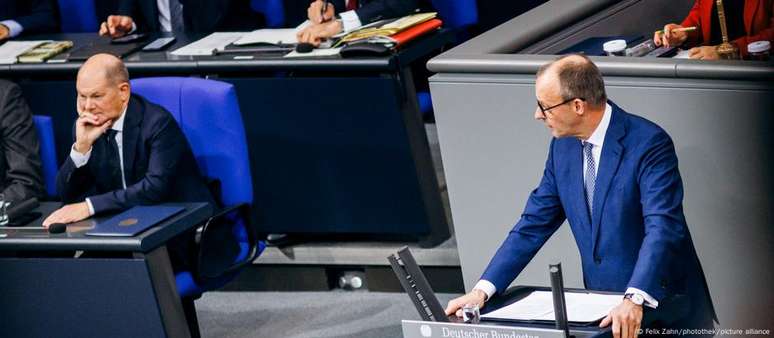 O líder nas pesquisas, Friedrich Merz (dir.), critica o governo de Olaf Scholz (esq.) em sessão no Bundestag