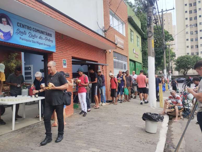 Pessoas em situação de rua recebem o café da manhã natalino distribuído pelo padre Júlio Lancellotti, na Mooca, em São Paulo. 